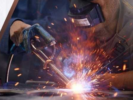 A welder at work, sparks flying from the arc